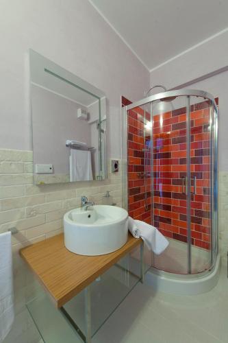 a bathroom with a sink and a glass shower at Hotel Zodiaco in Porto Cesareo