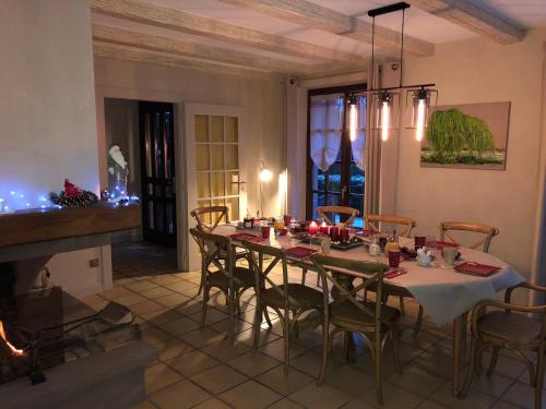 a dining room with a table with chairs and a fireplace at Les Chambres Chez Christine in Ottrott