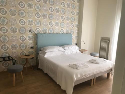 1 dormitorio con cama blanca y cabecero azul en 70's Luxury Cavour, en Bari
