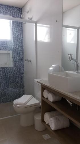 a bathroom with a sink and a toilet and a shower at Pousada Ilha das Conchas in Guarujá