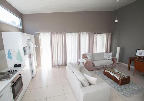 cocina y sala de estar con sofá y mesa en RnB's Studio Apartment en Windhoek