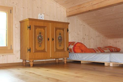 ein Schlafzimmer mit einem Bett und einem Schrank in einem Zimmer in der Unterkunft Chalet Nueschwendi in Ebnat