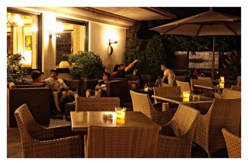 a group of people sitting in a restaurant with tables and chairs at Apparthotel Taufenbrunn in Parcines