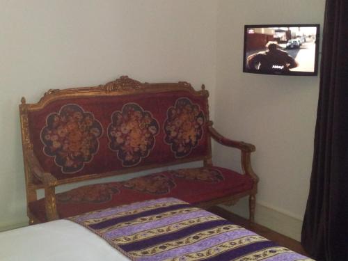 a bedroom with a bed and a tv on the wall at Whatever Art B&B in Lisbon
