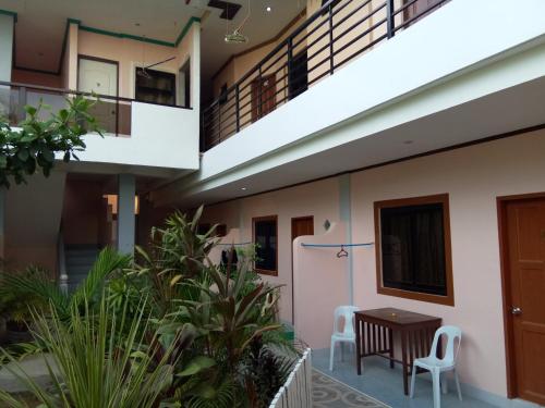 a building with a table and chairs in a courtyard at Alona KatChaJo Inn in Panglao Island