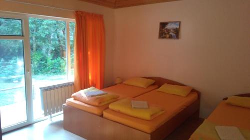 a bedroom with two beds and a large window at Hotel Valdis in Pastra