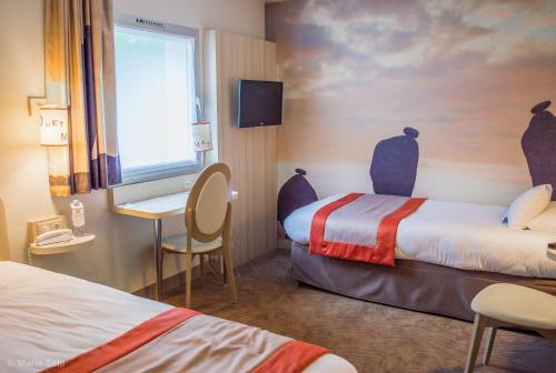 a hotel room with two beds and a desk and a window at Best Western Auray le Loch in Auray