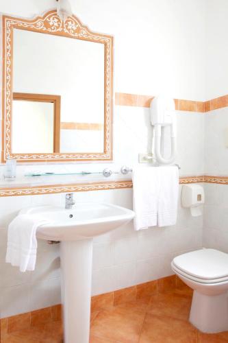 a bathroom with a sink and a mirror and a toilet at Hotel Elite Palermo Centro in Palermo