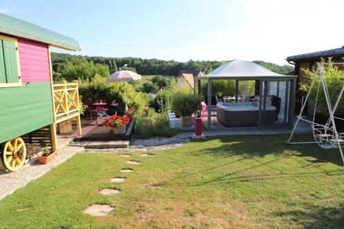 a garden with a colorful house and a gazebo at Roulotte la Dominique in Romery