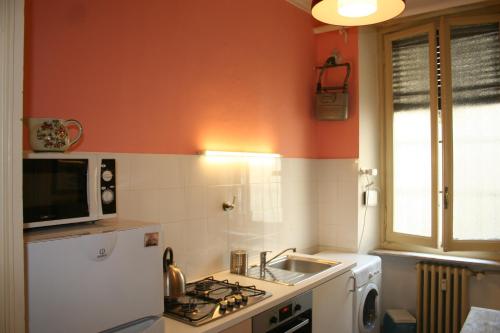 a kitchen with a white refrigerator and a sink at Appartamento Conte Rosso in Turin