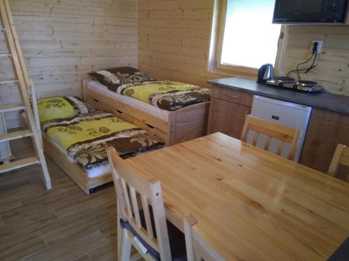 a dining room with two beds and a table at Chata Nový Přerov in Nový Přerov