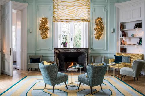 a living room with chairs and a fireplace at Domaine de la Tortinière in Montbazon