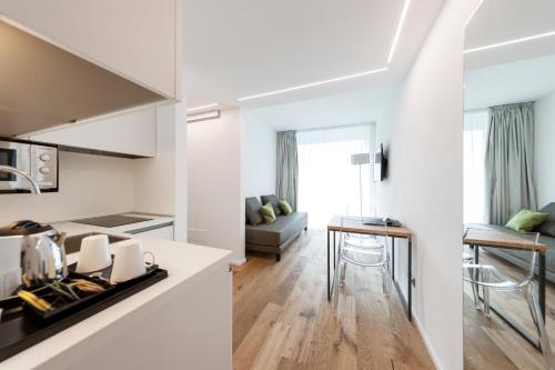a kitchen and living room with white walls and a table at ALEA - Garda Lake Suite in Arco