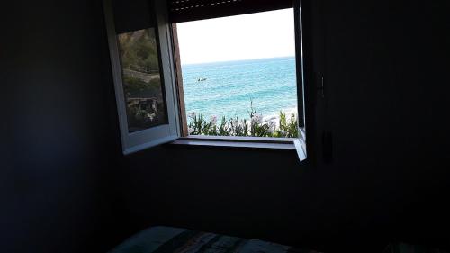 a window in a room looking out at the ocean at Villaggio Camping Fiorina in Capo Vaticano
