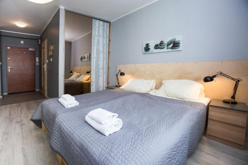 シュチェチンにあるApartamenty Sedinum - Brama Portowaのベッドルーム1室(ベッド1台、タオル2枚付)