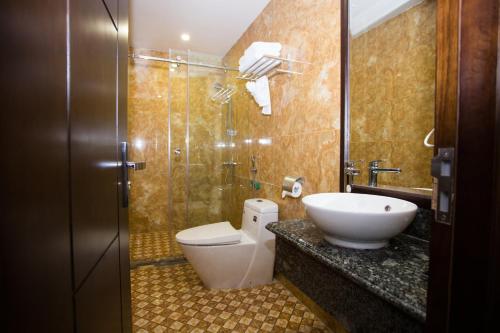 a bathroom with a toilet and a sink and a shower at Moc Tra Hotel Tuan Chau Hạ Long in Ha Long