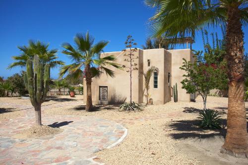a building with palm trees in front of it at Sole Caliente in Todos Santos