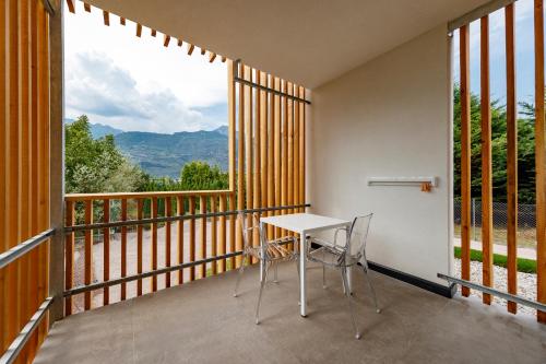 a balcony with a table and chairs and a large window at ALEA - Garda Lake Suite in Arco