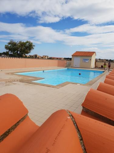 una gran piscina con techo naranja en Studio cabine au barcares, en Le Barcarès