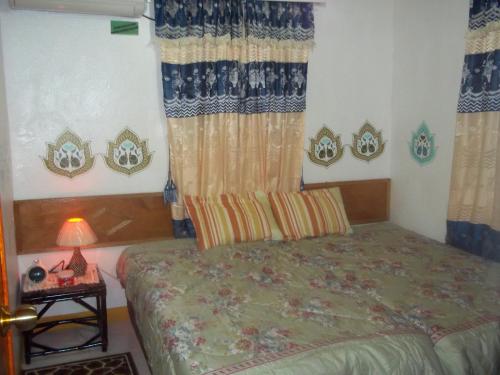 a bedroom with a bed and a table with a lamp at Marysol Lodging in San Andrés