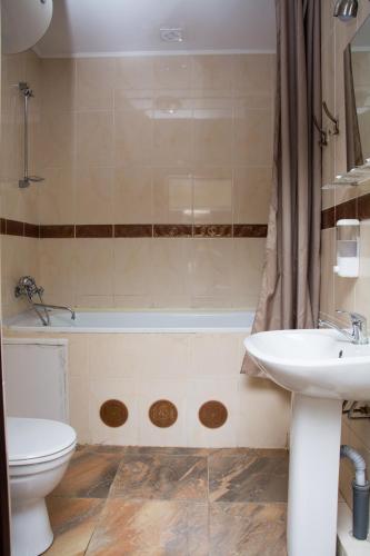 a bathroom with a sink and a toilet and a tub at Faraon Hotel in Ivano-Frankivsk