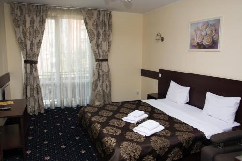 pokój hotelowy z łóżkiem i oknem w obiekcie Faraon Hotel w Iwano-Frankiwsku