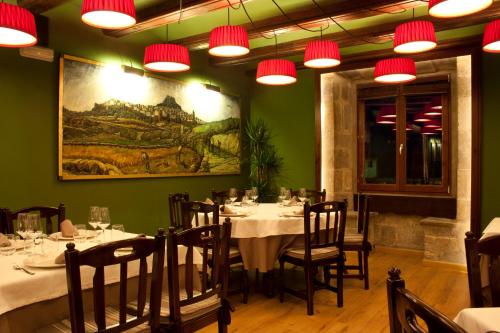 a dining room with tables and chairs and lights at Hotel Cardenal Ram in Morella