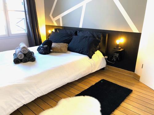 - une chambre avec un grand lit blanc et des oreillers noirs dans l'établissement La Suite Star Wars - SDP, à Magny-le-Hongre