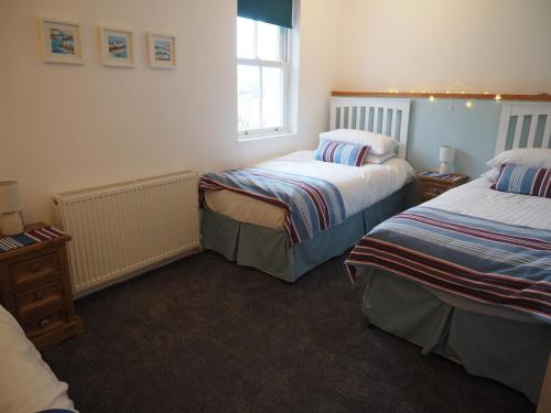 a bedroom with two beds and a window at The Old Legion in Eyemouth