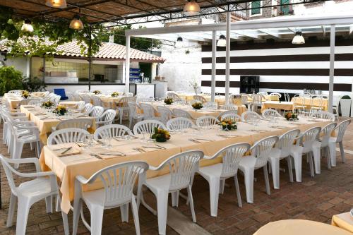 a group of tables with white chairs and tablesearcher at De Maria House in SantʼAgata sui Due Golfi