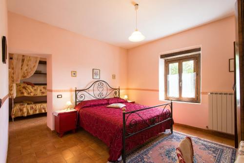a bedroom with a bed with red sheets and a window at Villa Valdarecchia in Apecchio