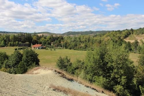 a field with a house in the middle of a field at Alcove Du Velay in Rochelimagne