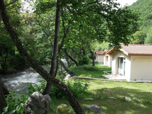 a house next to a river next to a house at Hotel Valdis in Pastra