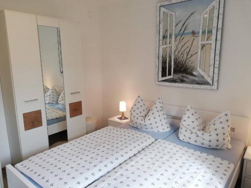 1 dormitorio con cama con almohadas y espejo en Seepferdchen, en Zingst