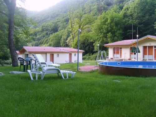 a yard with two chairs and a pool and a house at Hotel Valdis in Pastra
