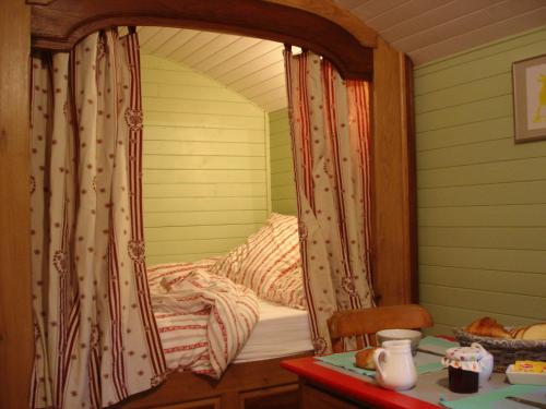 a bed in a room with a window with curtains at Roulotte Gabi in Rouville