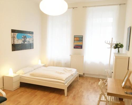 a white bedroom with a bed and a large window at Downtown Apartment Berlin Friedrichshain in Berlin