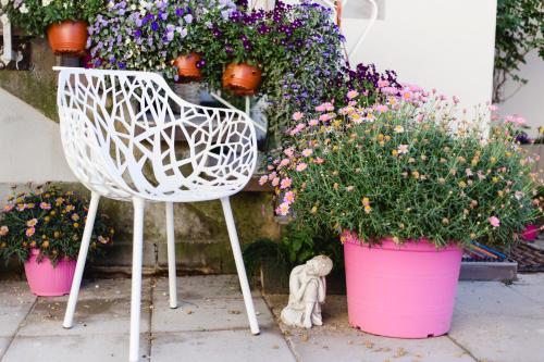 a white chair sitting in front of some flowers at House of Harmony in Stäfa
