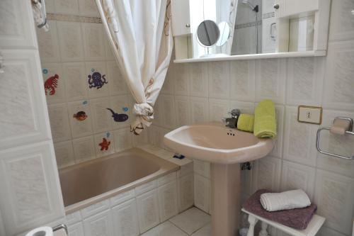 a white bathroom with a sink and a tub and a sink at eldorado blue in Playa de las Americas