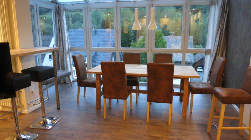 a dining room with a wooden table and chairs at Sauerland Juwel in Olsberg
