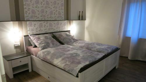 Bett in einem Schlafzimmer neben einem Nachttisch und einem Bett sidx sidx sidx in der Unterkunft Sauerland Juwel in Olsberg