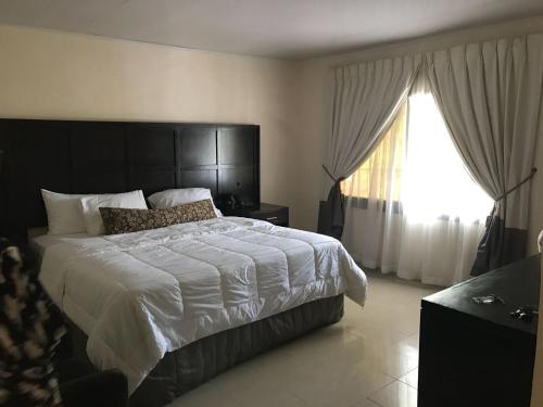 a bedroom with a large bed and a window at Hotel Cabenda in Freetown