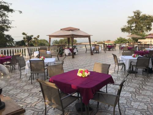 a patio with tables and chairs with purple table cloth at Hotel Cabenda in Freetown