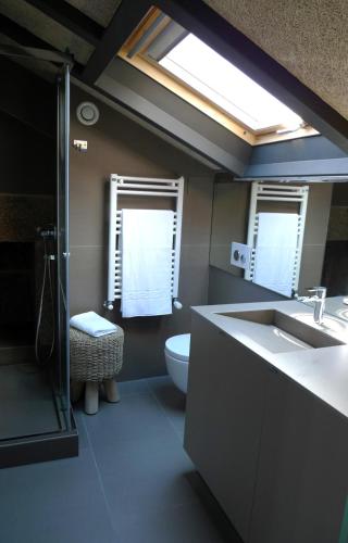 a bathroom with a sink and a toilet and a window at Blanco Apartamentos Turísticos in Santiago de Compostela