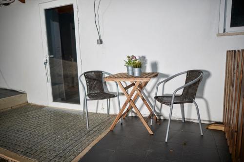 a small table with two chairs and a plant on it at Quinta da Villa in Cascais