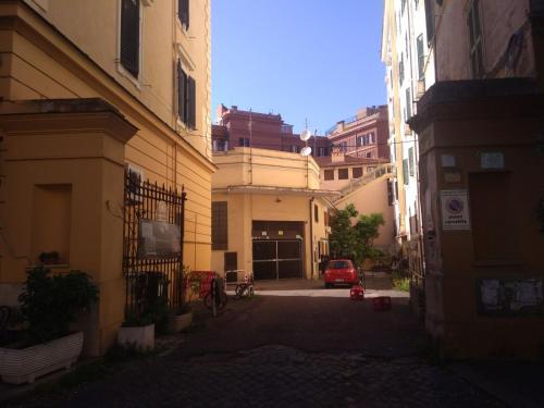 eine Gasse mit Gebäuden und einem roten Auto in der Ferne in der Unterkunft YourStay@Rome Vatican in Rom