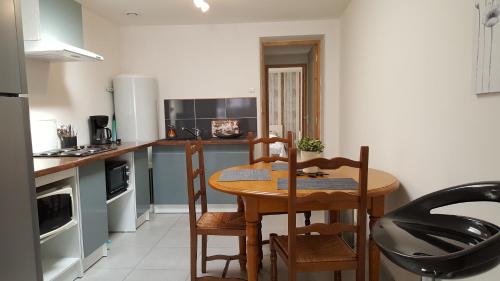 une cuisine avec une table et des chaises dans une pièce dans l'établissement maison style appartement à Béthune, à Béthune