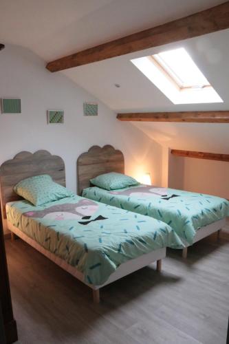 Duas camas num quarto com uma janela em Le Pailhé de Marius em La Salvetat