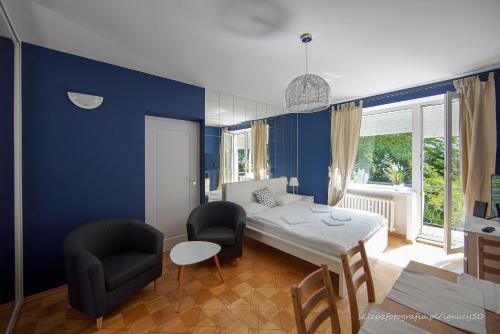 ワルシャワにあるSaska Kępa Apartamentyの青い部屋(ベッド1台、テーブル、椅子付)