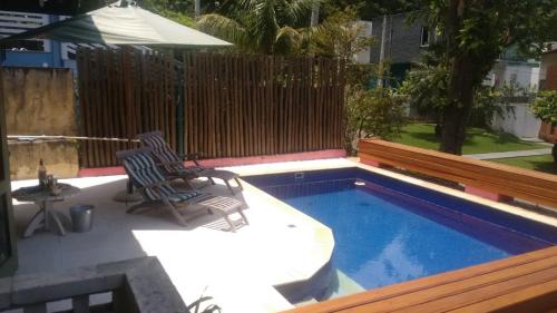 un patio con 2 sillas y una piscina en Casa em Toque Toque Pequeno, en Pauba